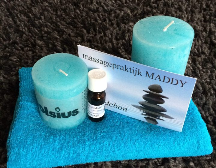 Kaarsen en massageolie met het kaartje van Massagepraktijk Maddy